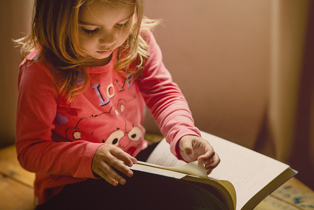 Little girl reading a book.
