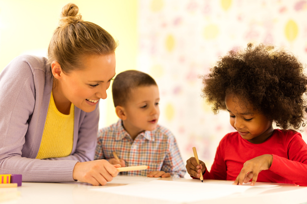 A woman and two children writing together.