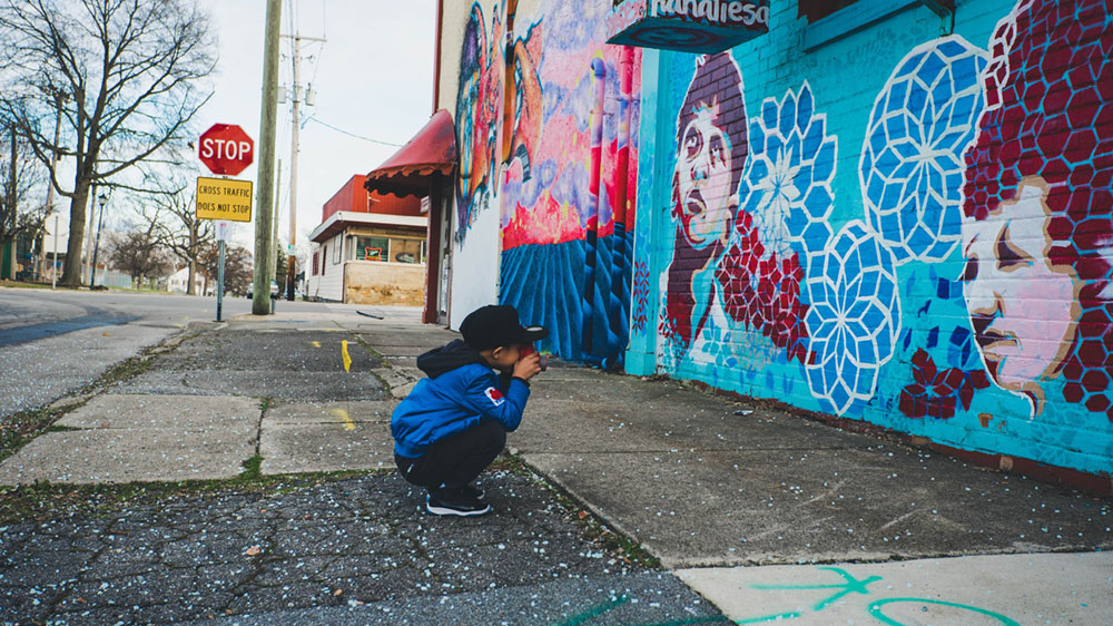 Child taking photo of mural