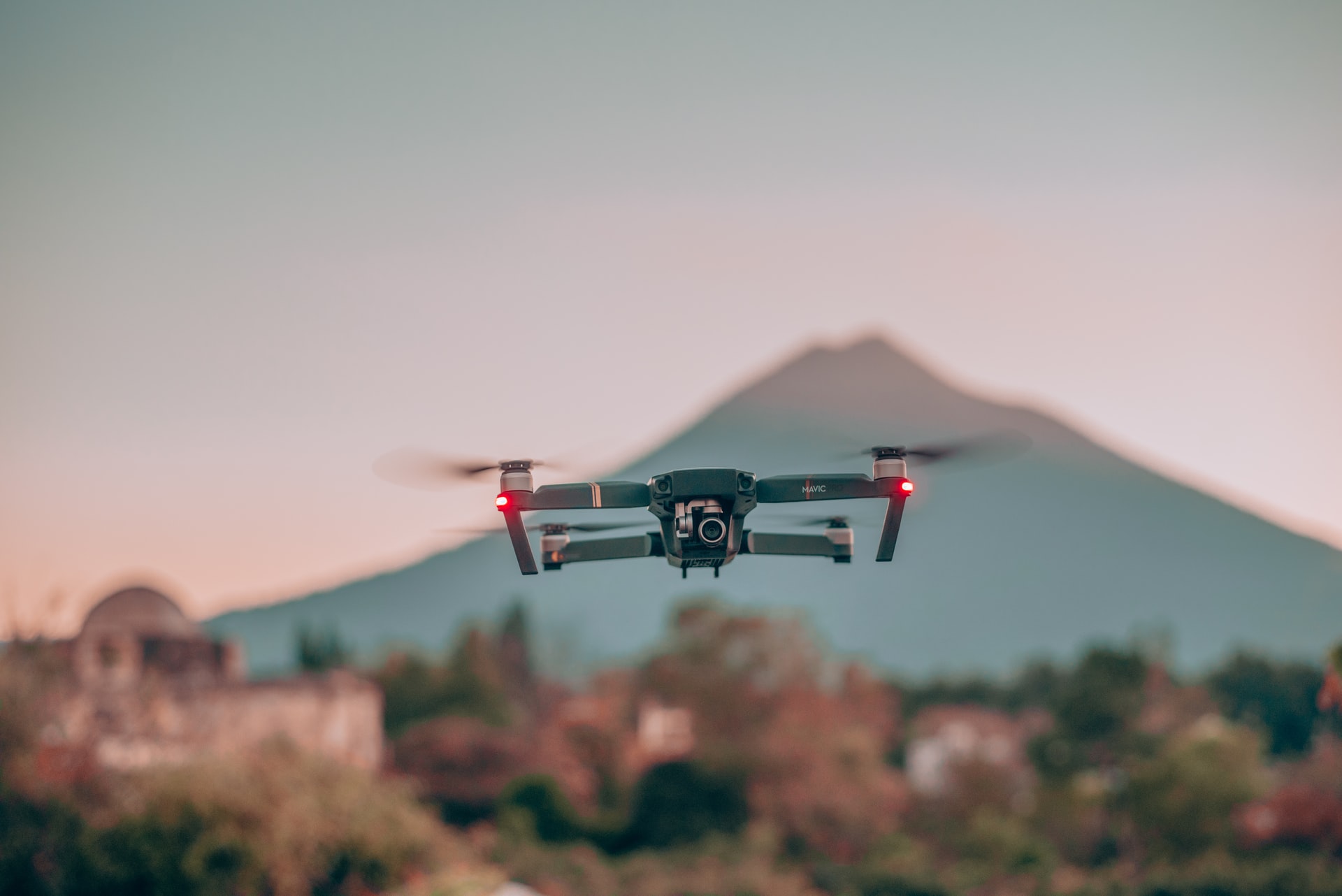 drone in mid air in day time with a mountain in the background