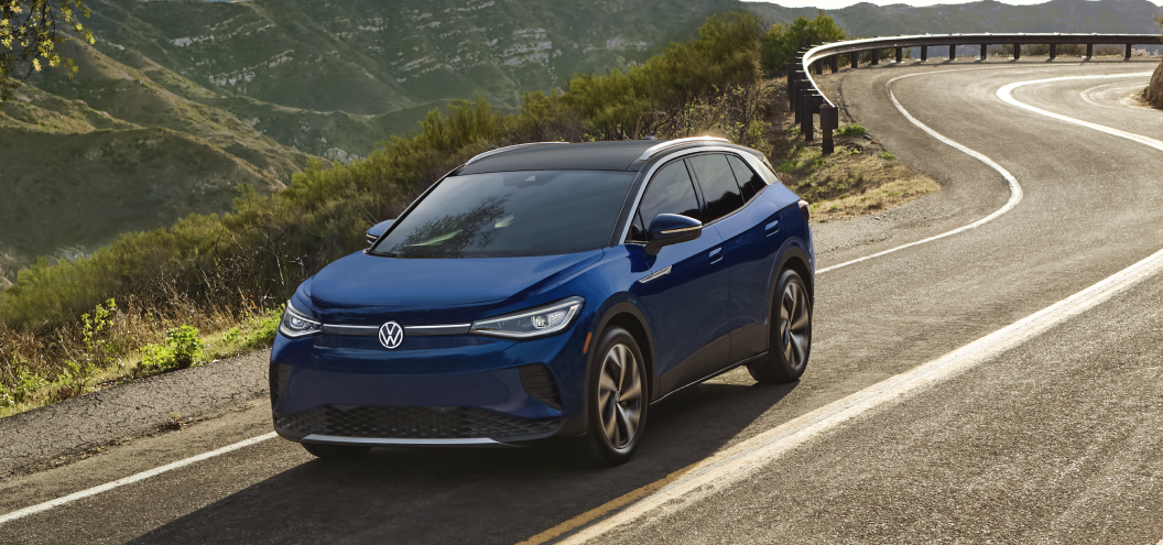 Blue Volkswagen e-golf electric car driving on a hillside