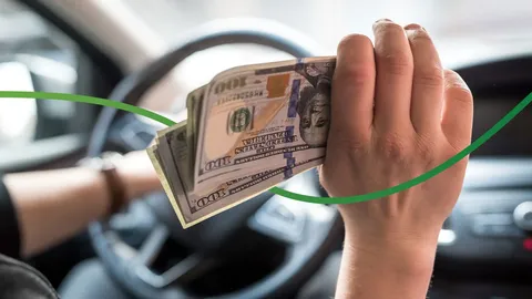 Hand Holding Hundred Dollar Bills While The Other Hand Is Holding A Steering Wheel