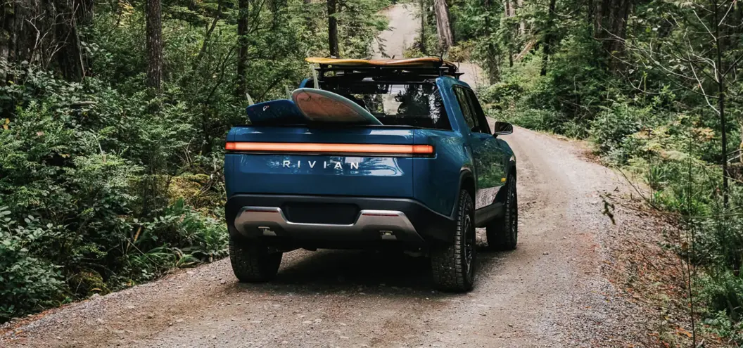 rivian driving on forested road