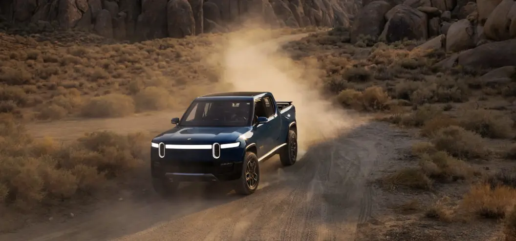 rivian driving on a dusty road
