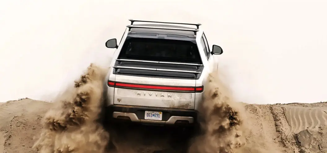 rivian driving over a sand dune
