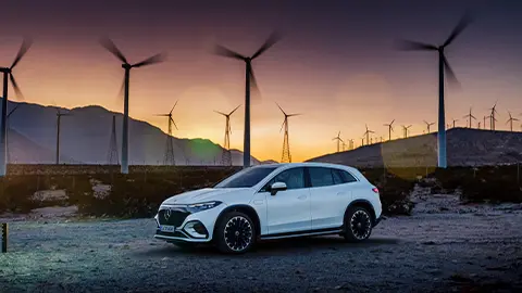 Mercedes Benz EQS with wind turbine farm in background