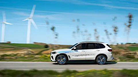 white hydrogen vehicle driving on scenic road