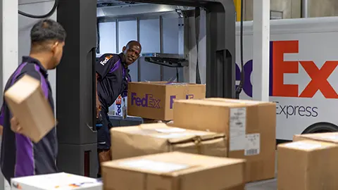 Fedex driver loads truck with boxes