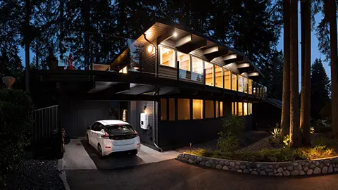 Electric car parked outside of home at night