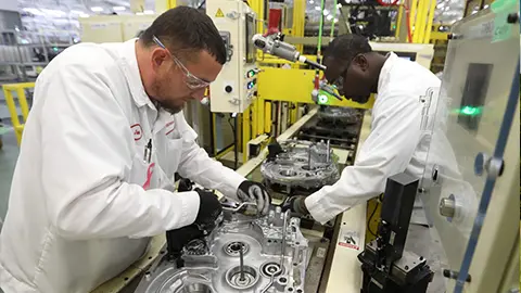 Two men working on building auto parts