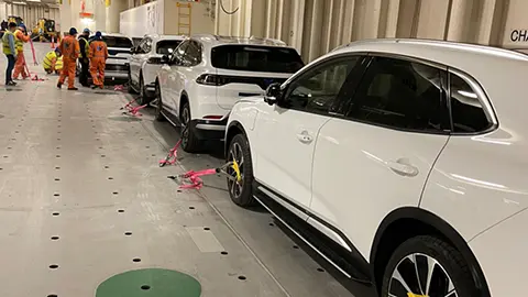 line of white vinfast vehicles leaving the manufacturing facility