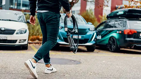 Hombre que lleva el cable del cargador del coche