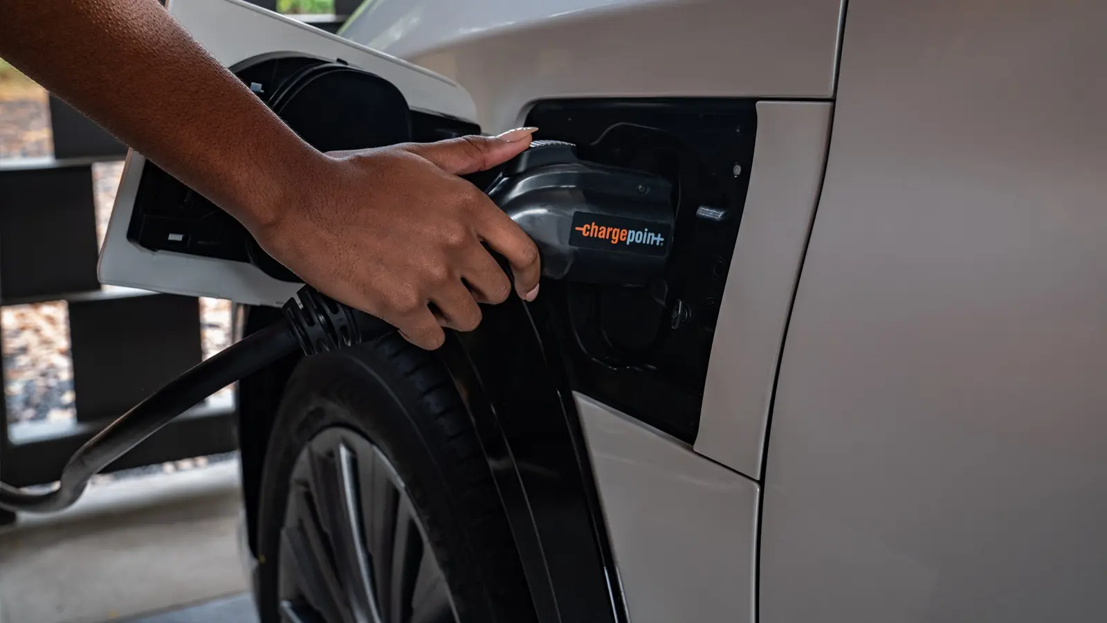 Close up of hand using Chargepoint charger for their EV.