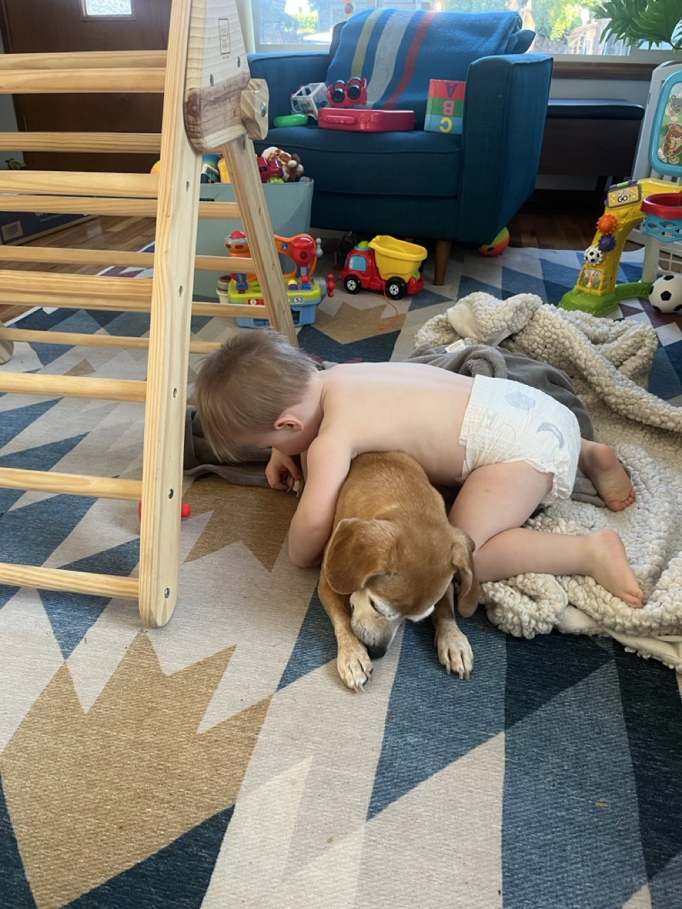 Our son Banks laying on our dog Chainsaw
