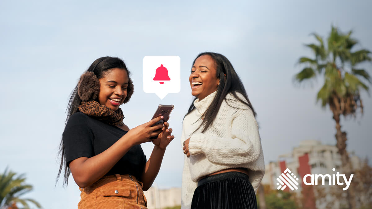 Two girls using a mobile phone and laughing