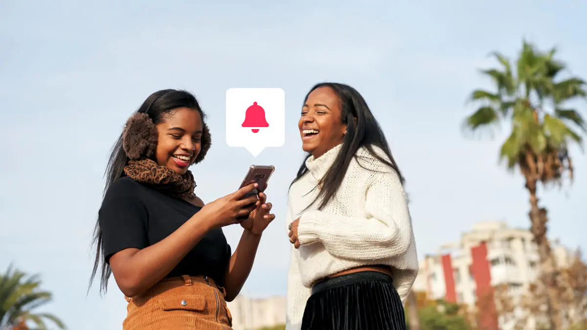 Two girls using a mobile phone and laughing