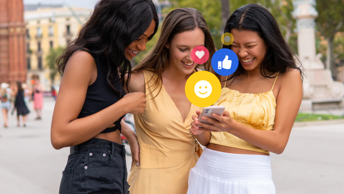 Cheerful friends with smartphone and social network on street