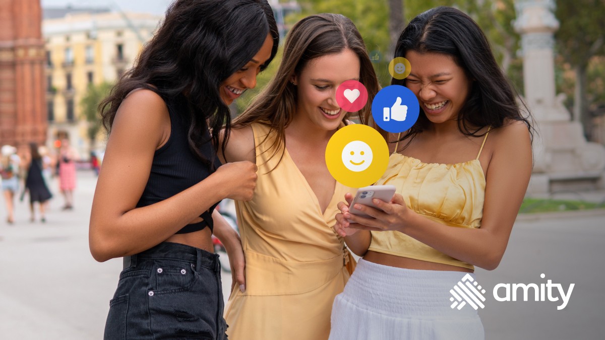 Cheerful friends with smartphone and social network on street