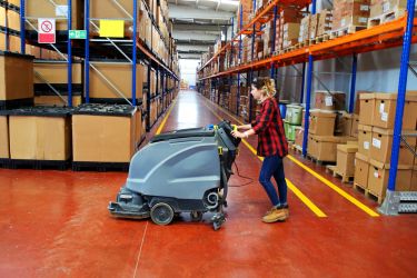 Woman cleaning the floors of the warehouse