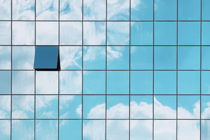 Skyscraper windows reflecting the sky and clouds