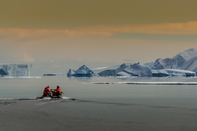 Climate scientists on a boat heading to study icebergs in the arctic