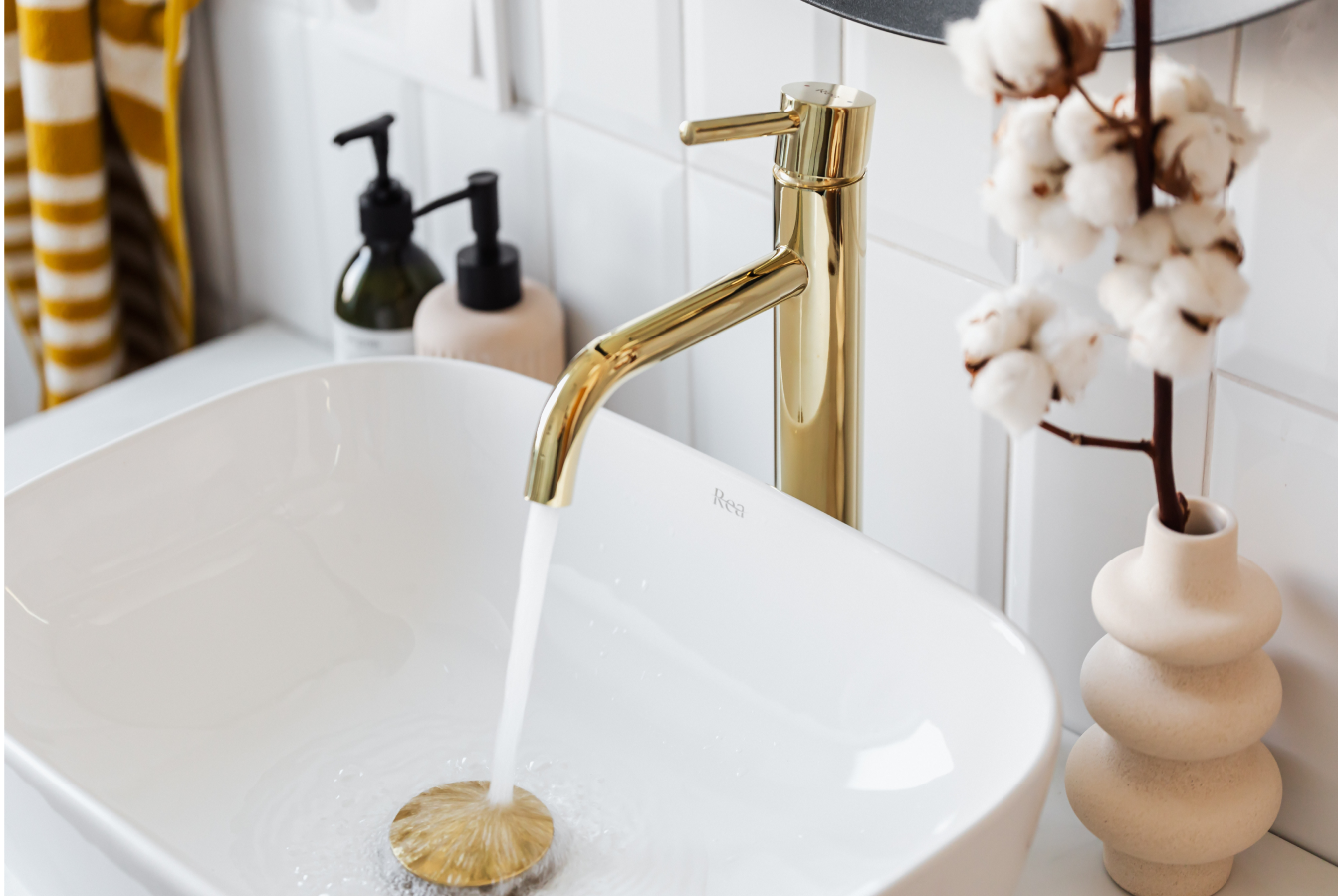 Gold faucet running into white porceline sink