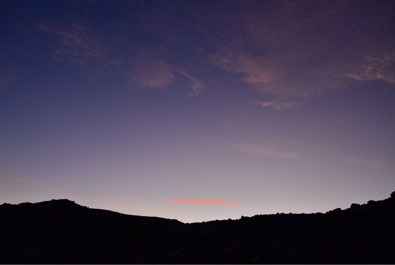 Mountains backlit by pink and purple sunset