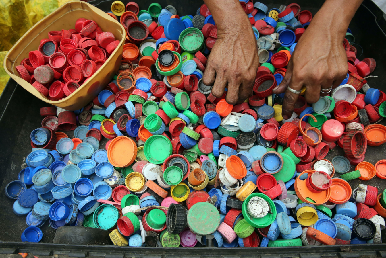 Pair of hands sorting plastic bottle caps