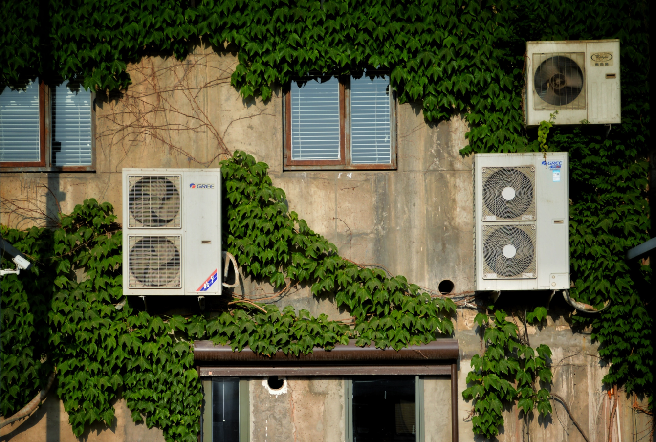 Air conditioning units on the side of a building, contributing to climate change.