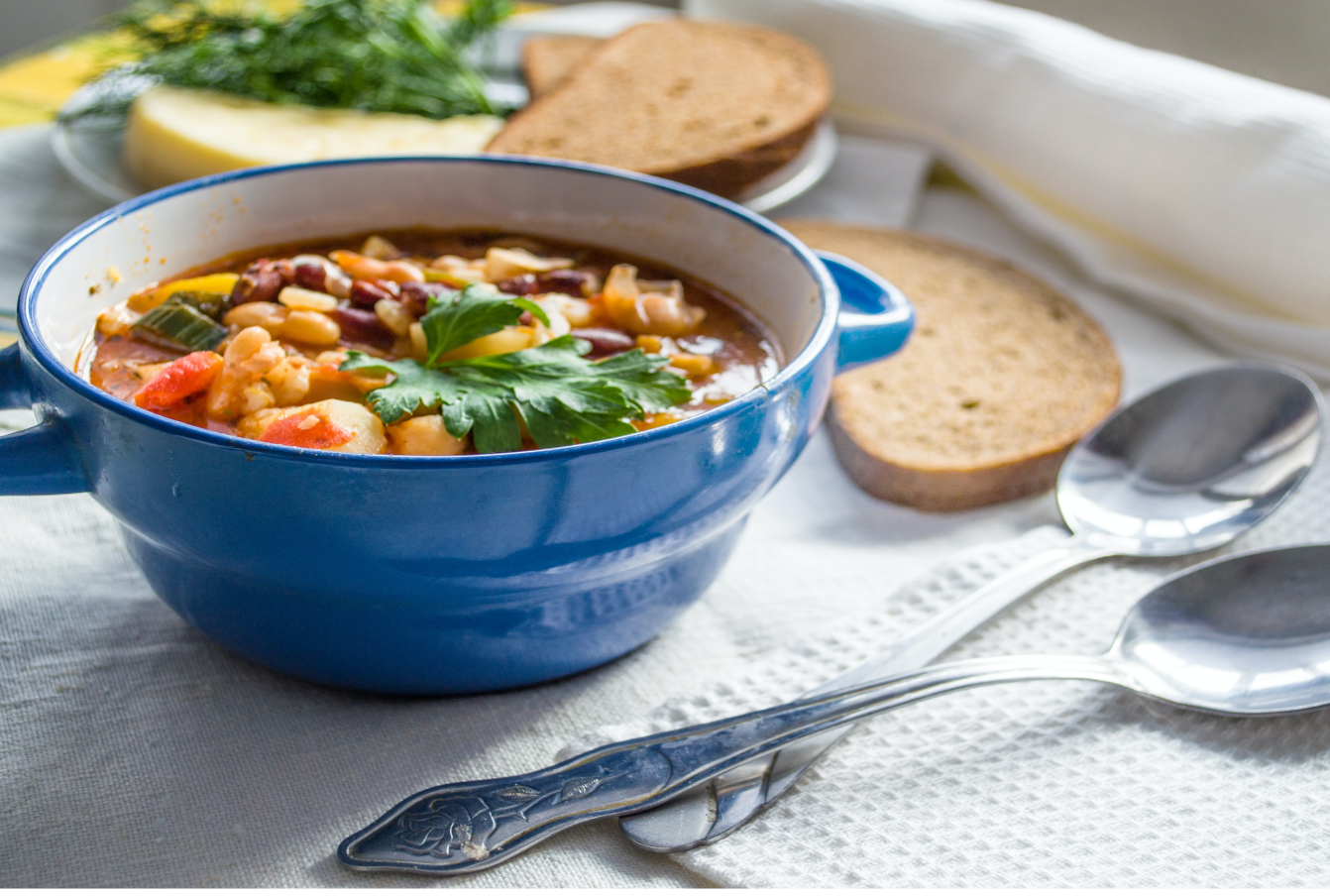 Bowl of vegetable soup containing beans and other legumes