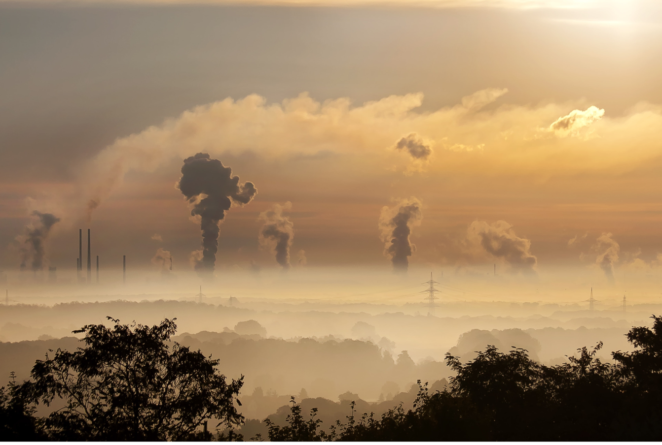 Factory smoke stacks emitting carbon dioxide in the distance