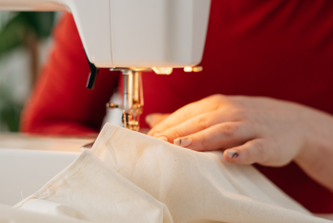 A person sewing an sustainable dress to give as a gift.