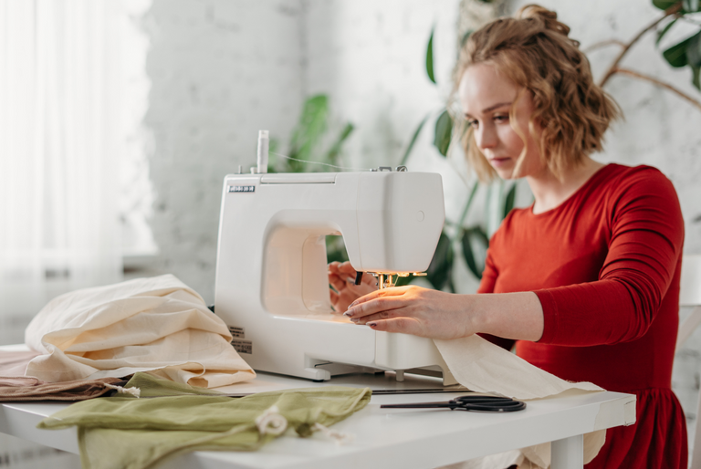 A women makes an repairs clothing on a sewing machine