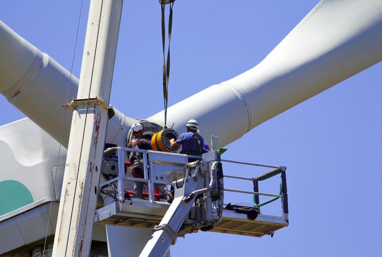 renewable energy technicians on top of wind turbine