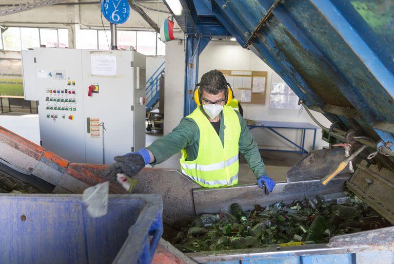 Hazardous waste manager sifting through recycling machine