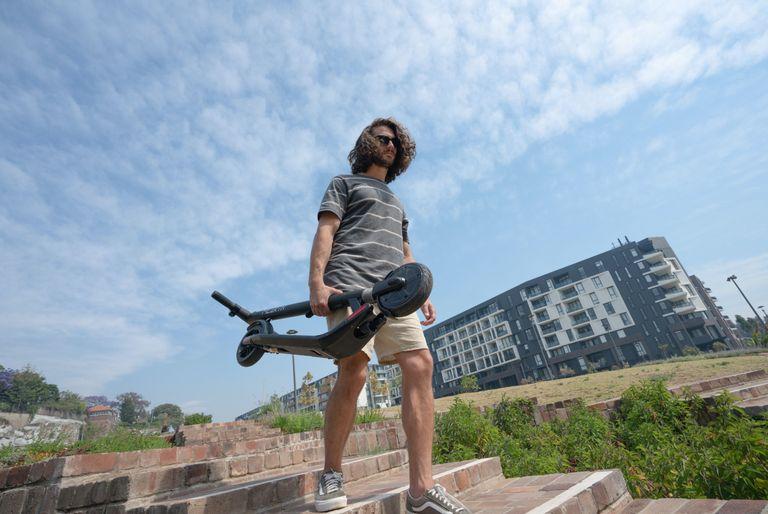 Man carrying electric foldable standup scooter