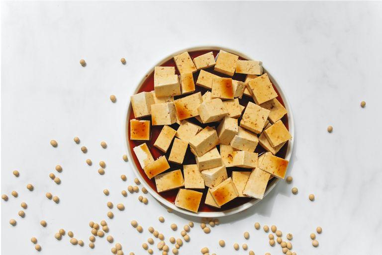 Sustainable tofu in a bowl being soaked in soy sauce for a no meat meal