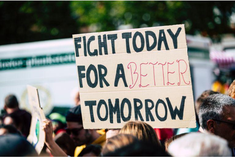 A climate change protest with a sign reading "fight for a better tomorrow".