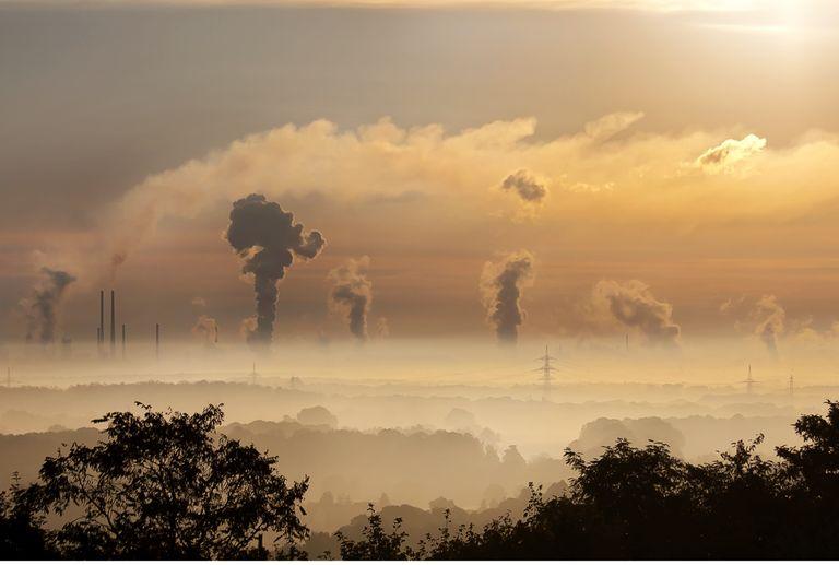 Factory smoke stacks emitting carbon dioxide in the distance