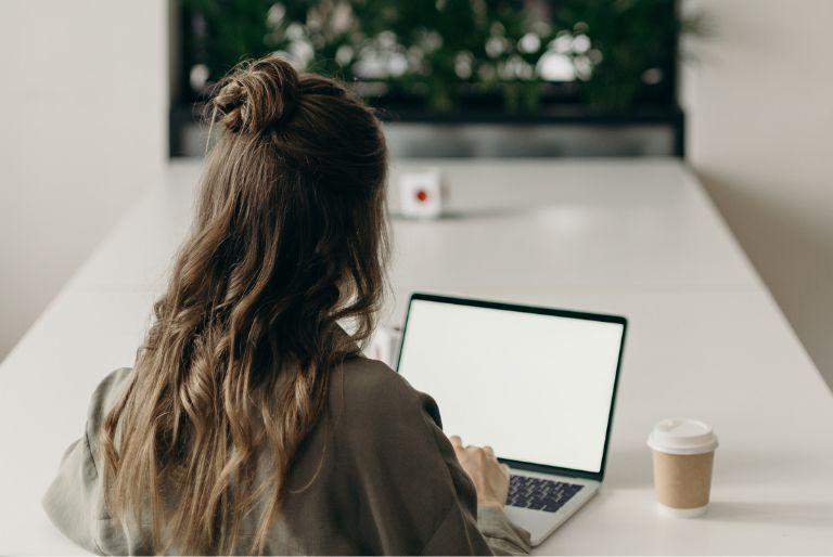 A woman purchasing a carbon offset on her laptop