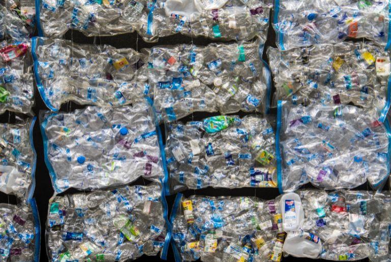 A wall of bags of plastic waste recycling.