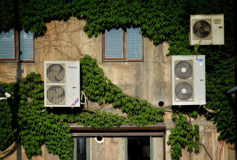 Air conditioning units on the side of a building, contributing to climate change.