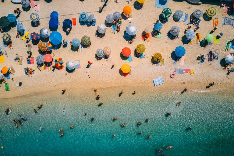 A large group of people vacationing on a beach. Vacations often create a huge individual carbon footprint.