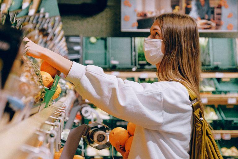 A girl choosing to shop for plant-based groceries while wearing a sustainable backpack.
