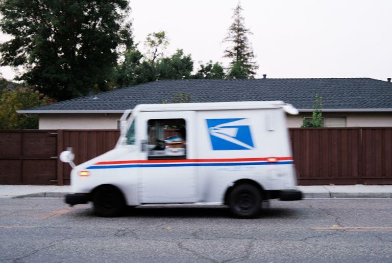 A USPS (United States Postal Service) truck delivering packages from online purchases.