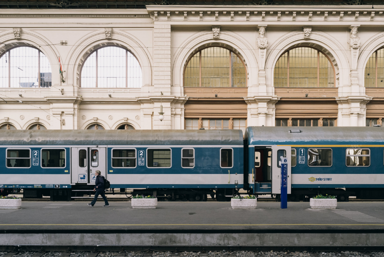 A blue train waits on a platform