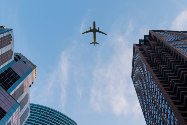 A view of an airplane flying over a city