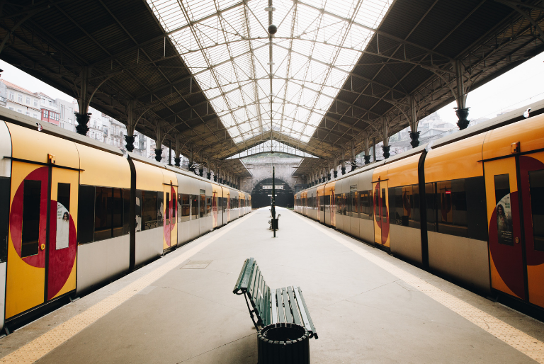 Two trains wait on the platform at a train station in Europe