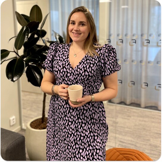 woman in purple dress holding a cup of coffee