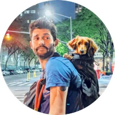 An image of a man with a dog in his backpack